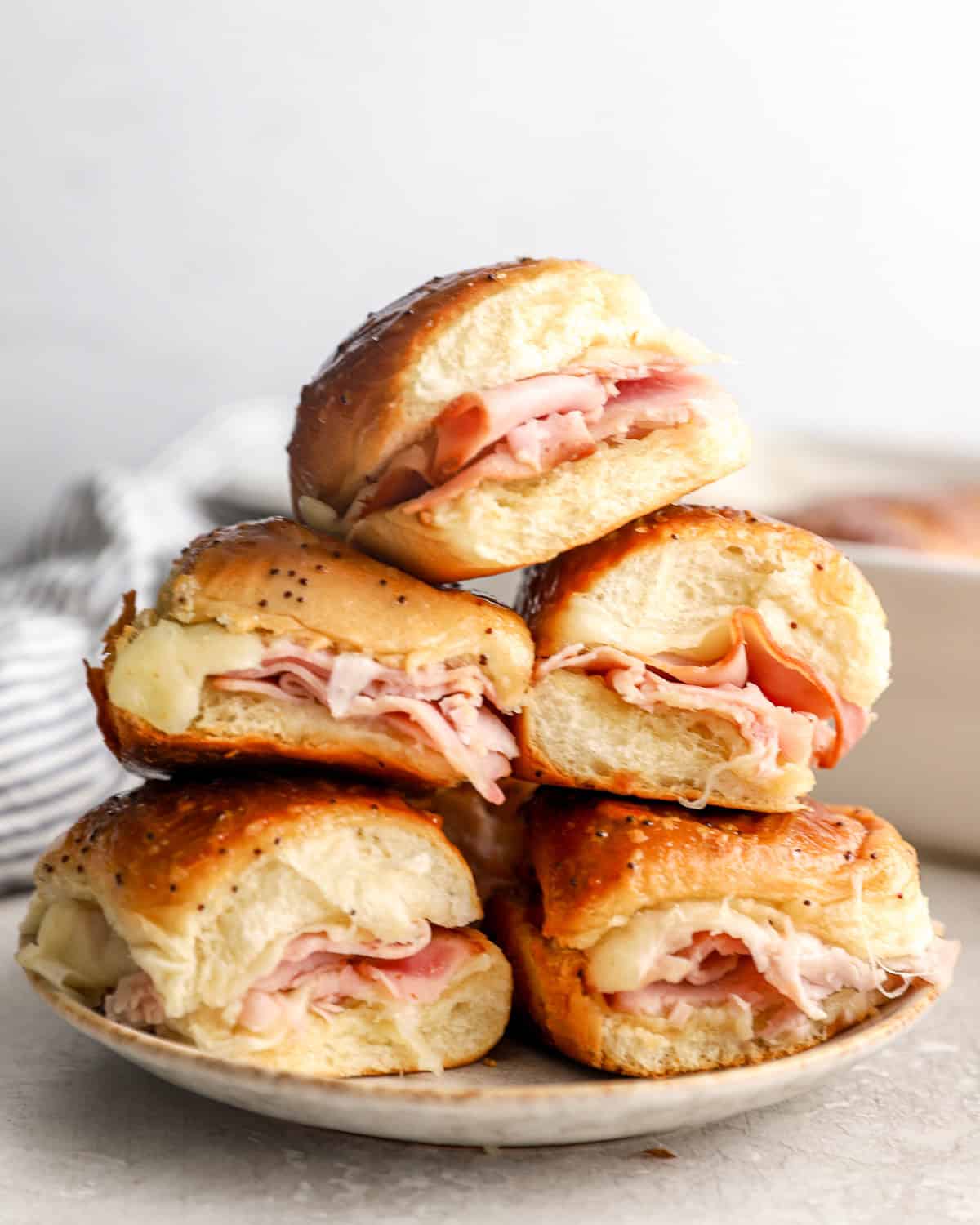 A plate of ham and cheese sliders on Hawaiian rolls.