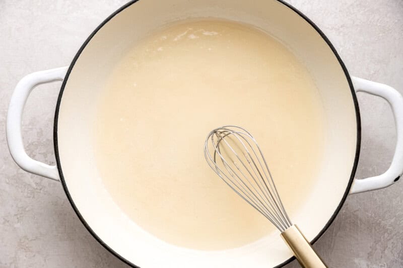 sugar and cornstarch dissolved in vinegar in a pot with a whisk.