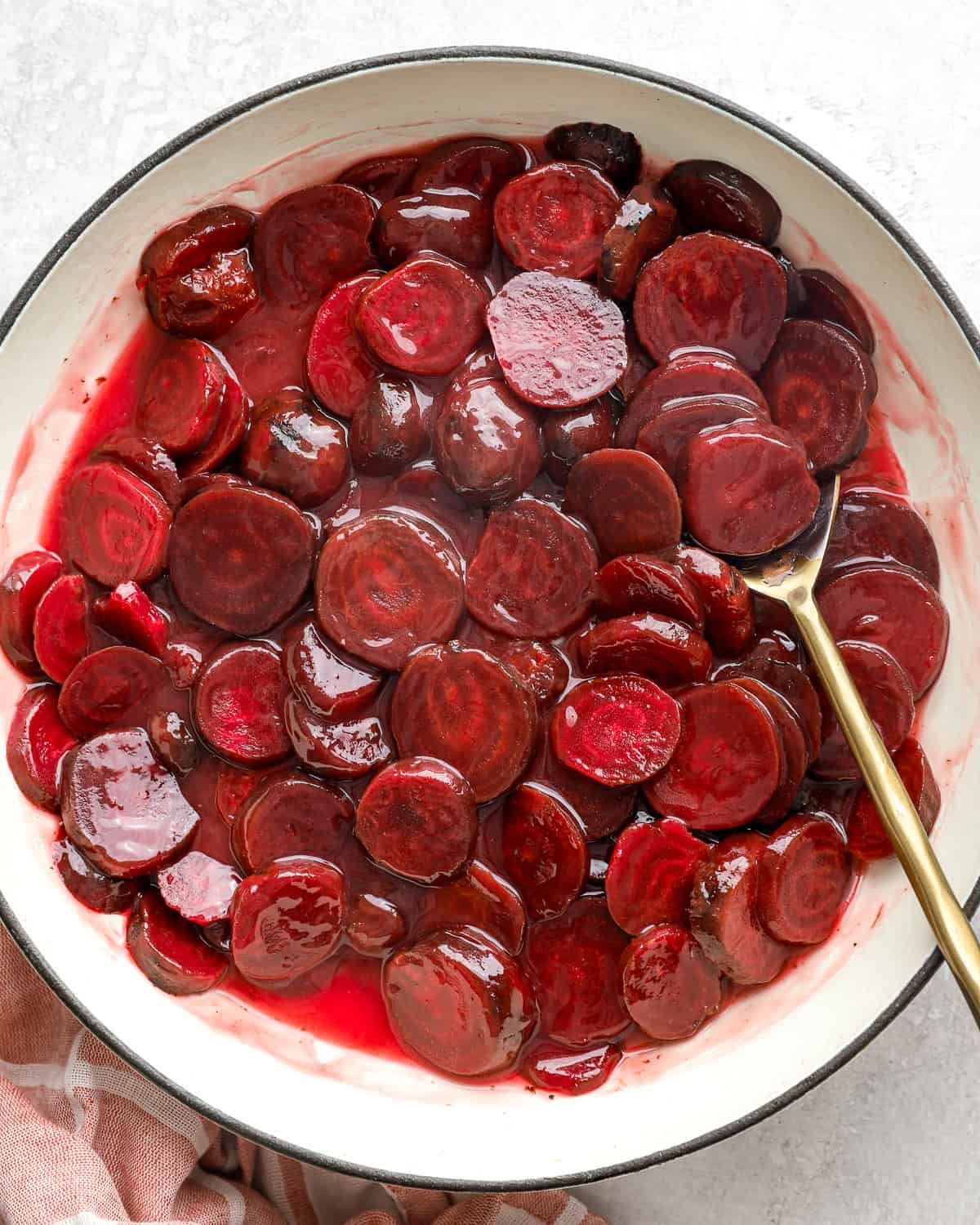 Harvard beets in a pot with a spoon.