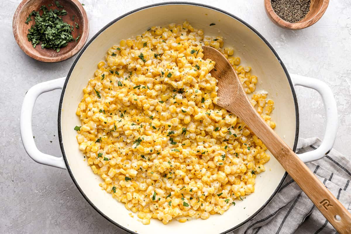 honey butter skillet corn topped with parsley in a pan.