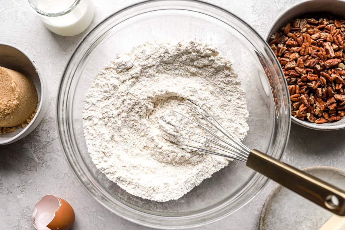 flour in a glass bowl with a whisk.