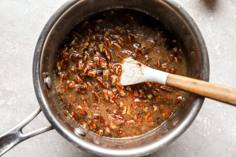 pecan pie filling in a saucepan with a rubber spatula.