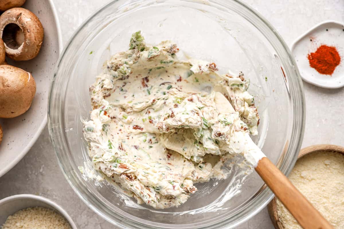 bacon cream cheese filling in a glass bowl with a rubber spatula.