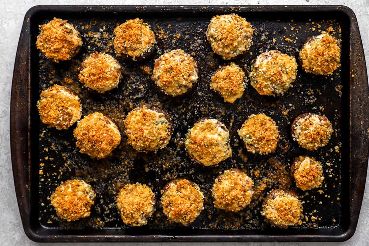 overhead view of bacon stuffed mushrooms on a baking sheet.