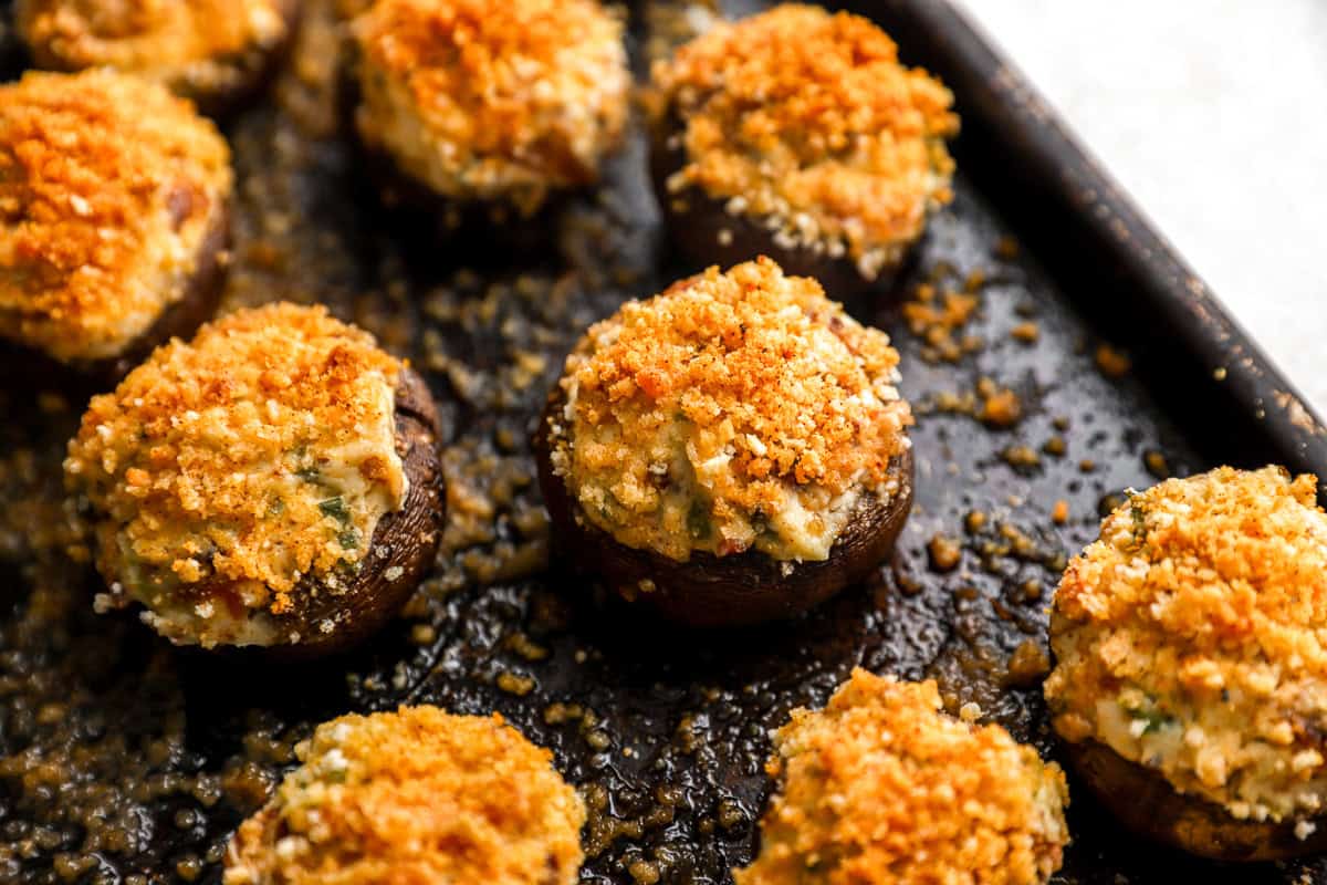 closeup view of bacon stuffed mushrooms on a baking sheet.