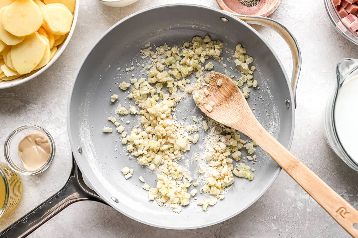 sautéed onion and flour in a pan with a wooden spoon.