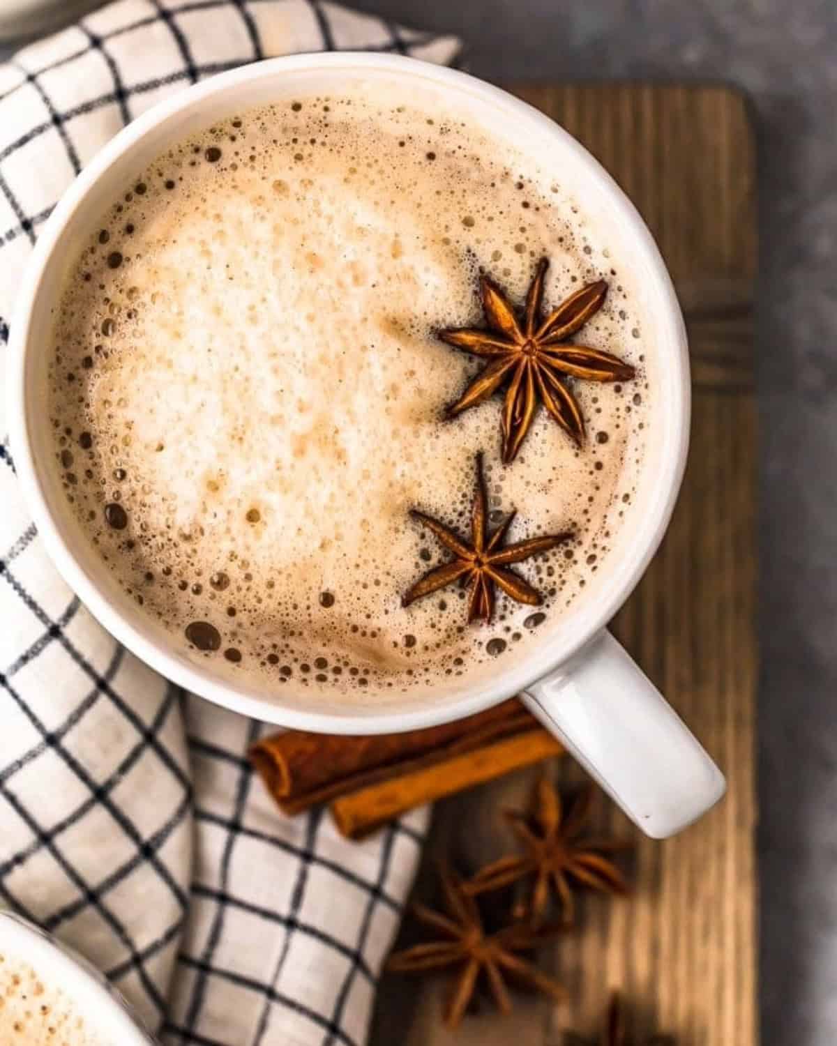 Overhead view of chai tea latte with bourbon in a mug, with star of anise floating on top.